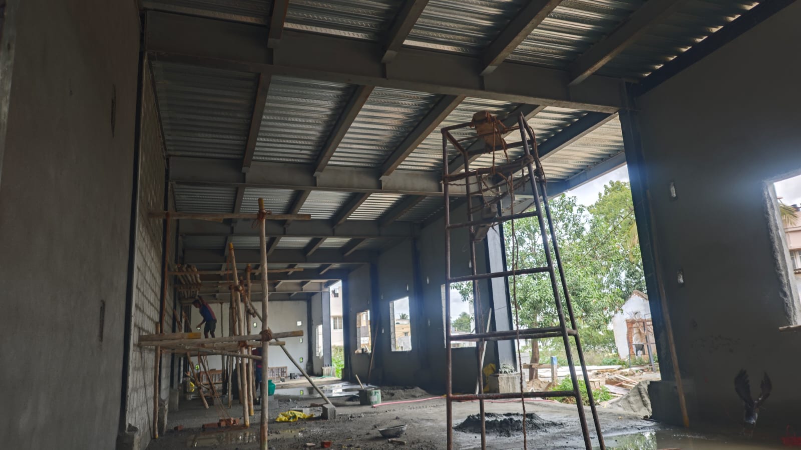 Workers on scaffolding inside a steel-framed building under construction