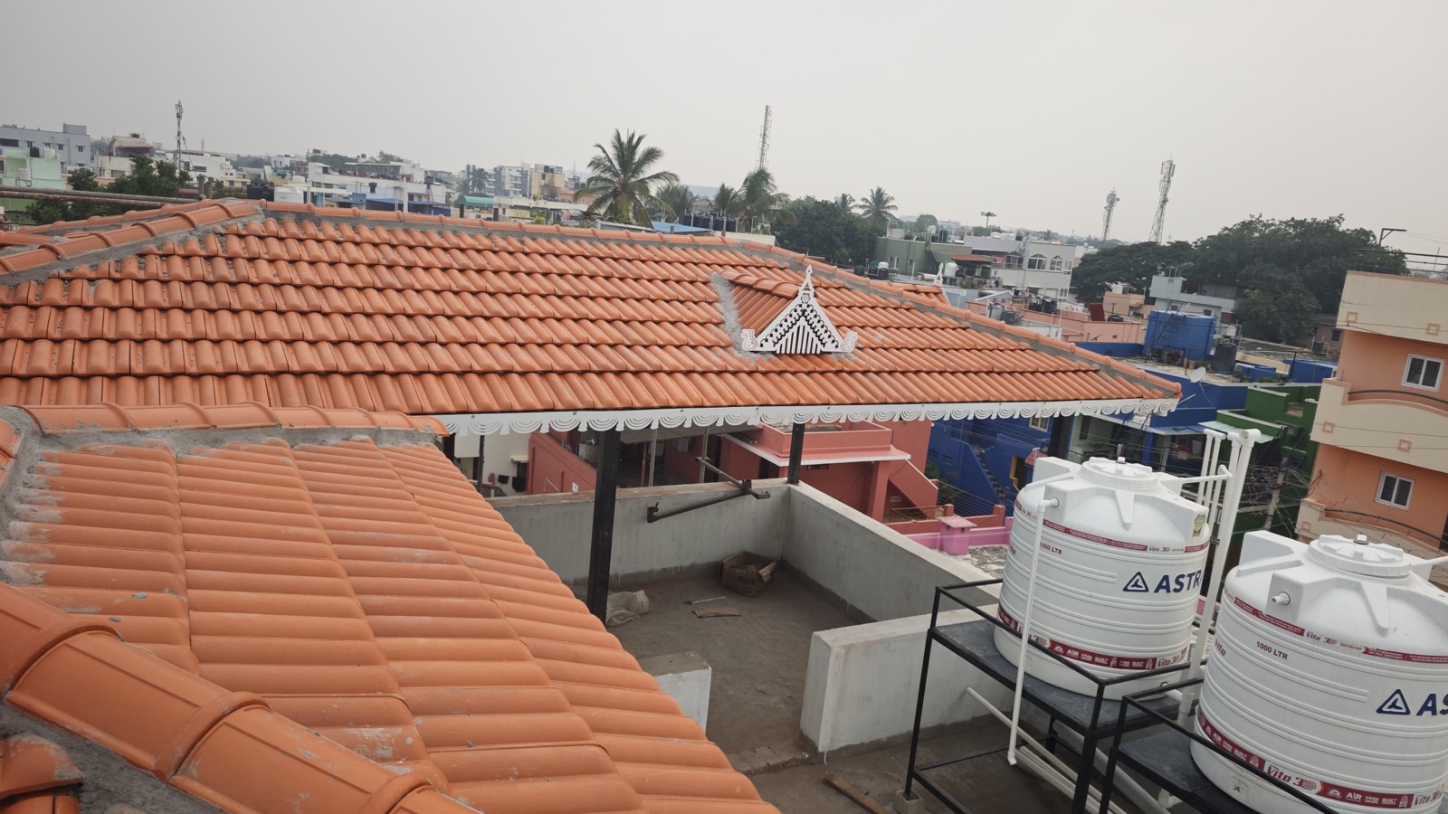 Aerial view of a terracotta tile roof installation with water tanks