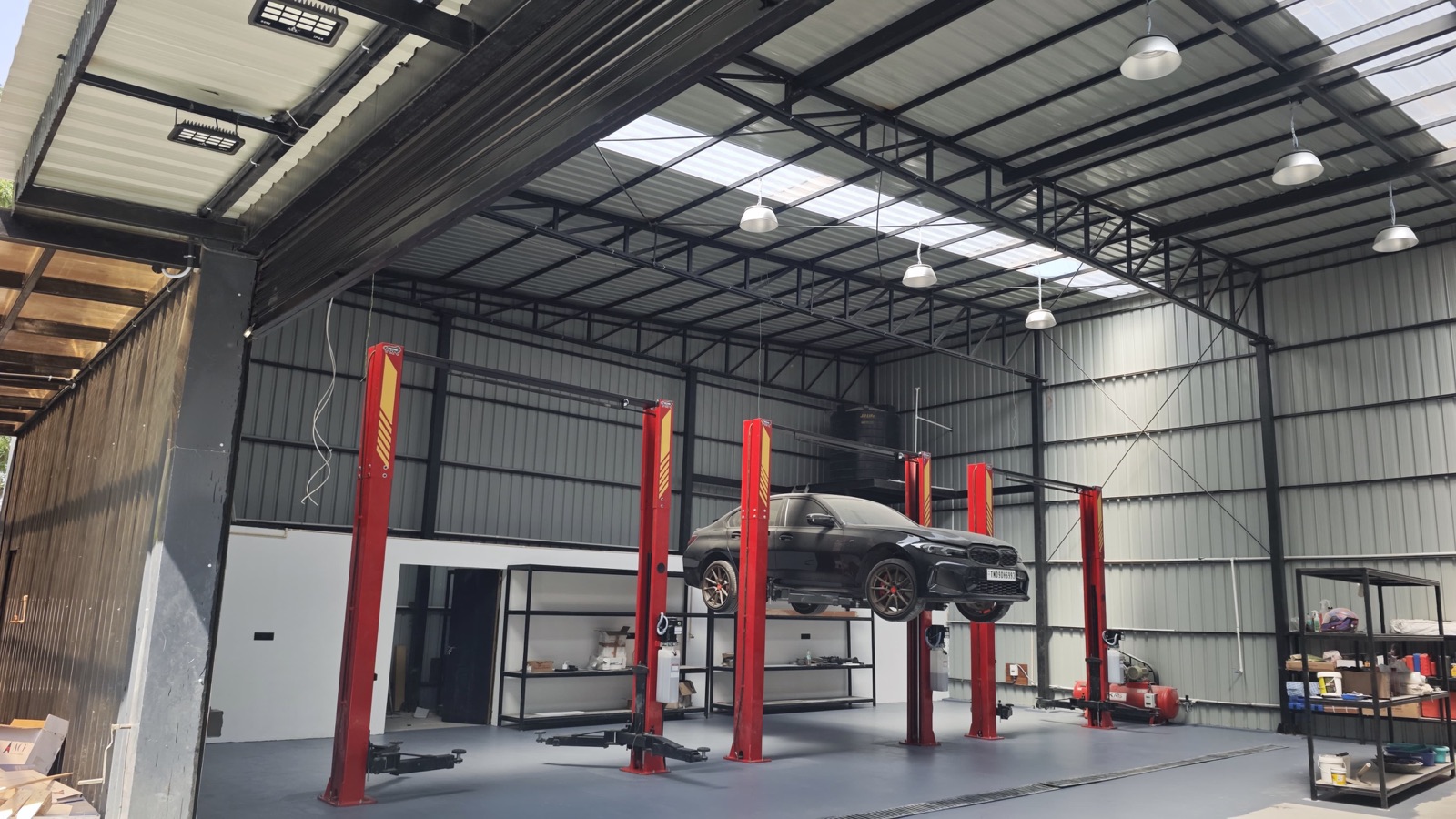 Automotive workshop interior with a car on a hydraulic lift