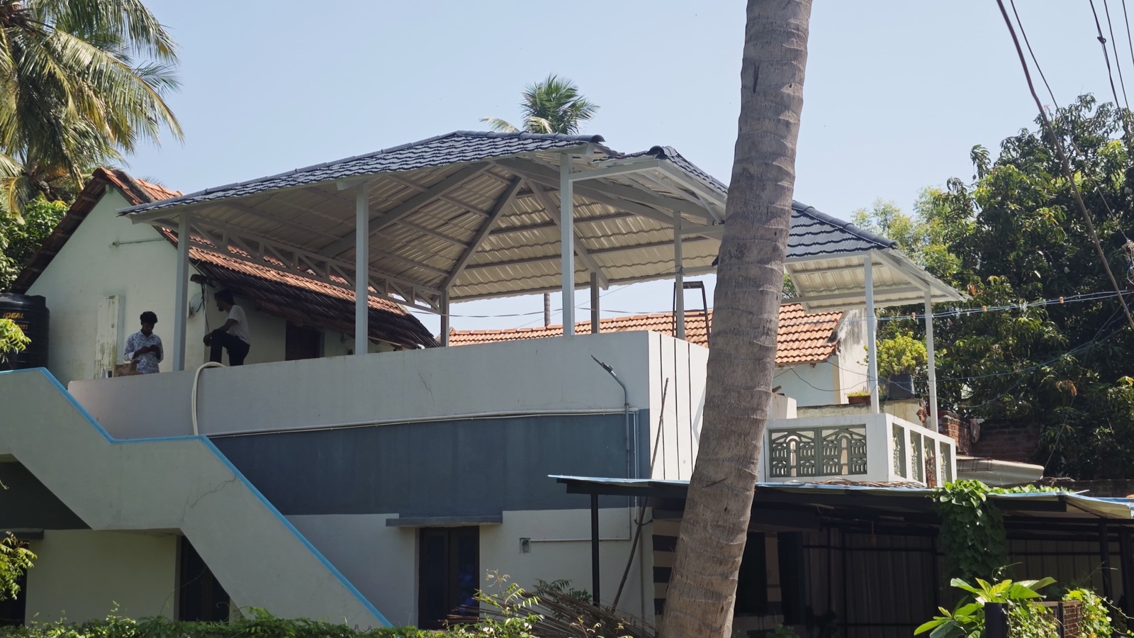 Rooftop terrace canopy structure surrounded by palm trees