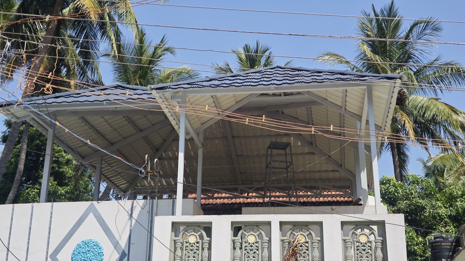 Terrace canopy structure with shingled roof and palm trees